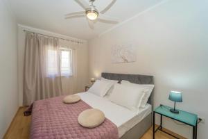 1 dormitorio con 1 cama grande con manta rosa en Apartment T&R, en Vela Luka