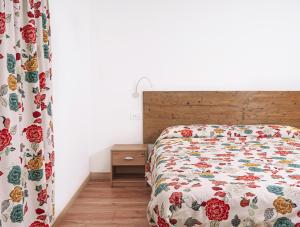 a bedroom with a bed with a floral bedspread at La Casa del Ciliegio in Feltre