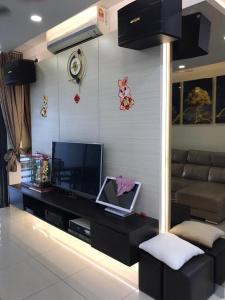 ein Wohnzimmer mit einem TV und einem Sofa in der Unterkunft Lakepark Residence KL North in Kuala Lumpur