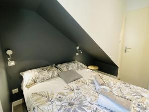 een slaapkamer met een bed met een zwarte muur bij Chez PISTACHE in Rodez