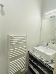 een badkamer met een wastafel en een spiegel bij Chez PISTACHE in Rodez