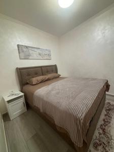 ein Schlafzimmer mit einem großen Bett und einem Nachttisch in der Unterkunft Petar Apartment in Podgorica