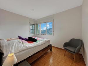 a bedroom with a bed and a chair and a window at Family Mountain Hideway in the Swiss Alps in Arbaz +11 photos