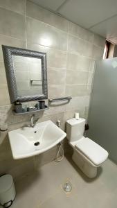 a bathroom with a sink and a toilet and a mirror at Wadi rum Gory camp in Disah