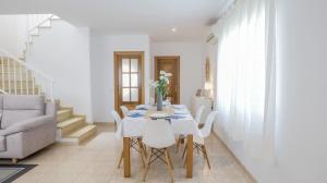 a white dining room with a table and chairs at Casa Mar con piscina privada AA y Wi-Fi delante del mar. in Vinaròs
