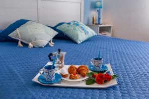 een dienblad met ontbijtproducten op een bed bij A'Mari - Holiday Home - Sciacca in Sciacca