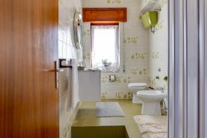 a bathroom with a toilet and a sink and a window at A'Mari - Holiday Home - Sciacca - 100mt dalla spiaggia Foggia - 100 meters from the beach in Sciacca +29 photos
