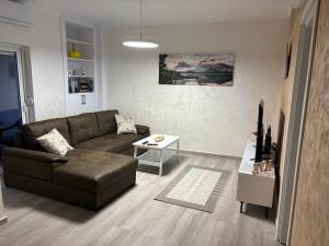ein Wohnzimmer mit einem Sofa und einem Tisch in der Unterkunft Petar Apartment in Podgorica