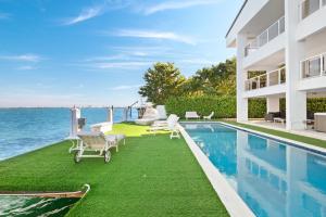 a house with a swimming pool next to the ocean at Villa Milli in Miami