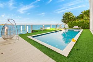 una piscina con altalena accanto all'acqua di Experience Opulence Your Exclusive Waterfront Sanctuary in Miami Beach a Miami