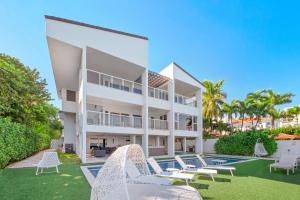 a large white building with chairs and a swimming pool at Villa Milli in Miami