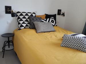una cama con muchas almohadas encima en Gîte de charme au Paradou. Piscine. Terrasse bois., en Paradou