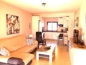 uma sala de estar com um sofá e uma cozinha em Beach and golf 4 Bedroom Holiday Home em Maspalomas