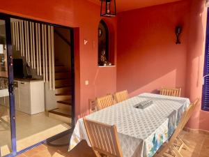 uma sala de jantar com uma mesa e cadeiras e uma escadaria em Beach and golf 4 Bedroom Holiday Home em Maspalomas