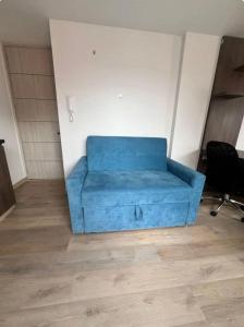 een blauwe bank in de hoek van een kamer bij Loft en Monserrate in Bogota