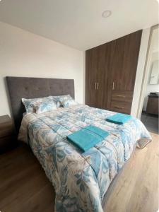 een slaapkamer met een bed met blauwe kussens erop bij Loft en Monserrate in Bogota