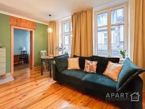 a living room with a black leather couch at Gdansk Central Apartment in Gdańsk