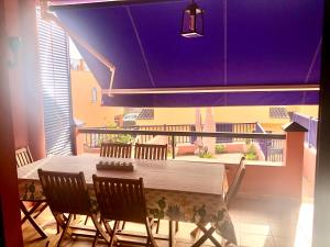 a table and chairs on a balcony with a purple ceiling at Beach and golf 4 Bedroom Holiday Home in Maspalomas