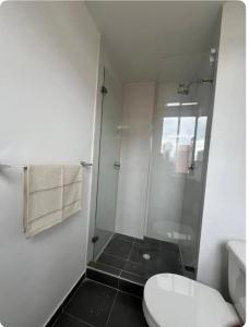 een badkamer met een toilet en een glazen douche bij Loft en Monserrate in Bogota