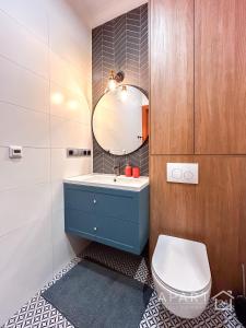 a bathroom with a blue sink and a mirror at Gdansk Central Apartment in Gdańsk