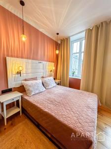 1 dormitorio con 1 cama grande y paredes de color rosa en Central Old Town Apartment en Gdansk