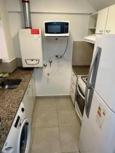 a small kitchen with a refrigerator and a microwave at Departamento en Plaza España in Córdoba