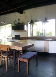 uma cozinha com uma mesa de madeira e algumas cadeiras em Domaine de La Beurrerie, déconnectez Naturellement em Saint-Mesmin