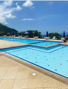uma grande piscina com água azul em Apartamento Completo Porto Real Resort em Mangaratiba
