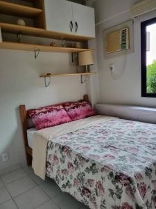 曼加拉蒂巴的住宿－Apartamento Completo Porto Real Resort，一间卧室配有一张带花卉床罩的床