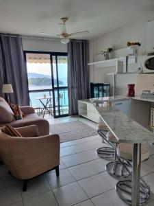 曼加拉蒂巴的住宿－Apartamento Completo Porto Real Resort，厨房以及带桌椅的起居室。