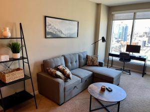 een woonkamer met een bank en een tafel bij Heart of Downtown Calgary Spacious Luxury Condo with Stunning Views and Premium Amenities in Calgary