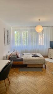 a bedroom with a large bed and a large window at Mermaid house apartman in Szeged