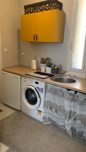 a kitchen with a washing machine and a sink at Mermaid house apartman in Szeged