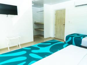 una camera con un letto e un tappeto blu di Hotel Caribbean Coral a San Andrés