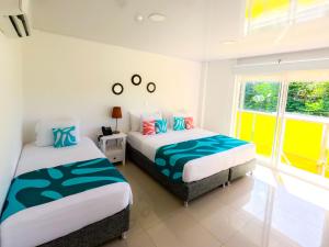 圣安德烈斯Hotel Caribbean Coral的有两张床和一扇窗户的卧室