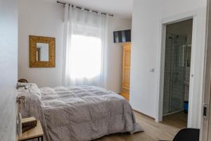a bedroom with a bed and a window and a shower at Affittacamere l'Aurora in Ceparana