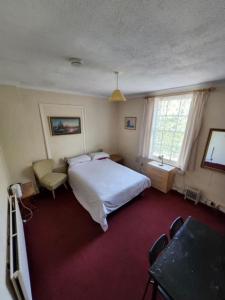 a bedroom with a bed and a table and chairs at The Lion Brewery in Ash