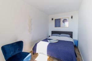 a bedroom with a bed and a blue chair at Horizon bleu in Cassis