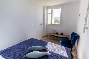 a bedroom with a bed and a table and a window at Horizon bleu in Cassis