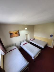 a room with three beds in a hospital at The Lion Brewery in Ash