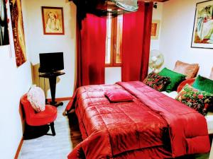 1 dormitorio con cama roja y manta roja en Chambres Du Petit Bonheur, en Biscarrosse