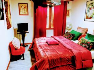 a bedroom with a red bed with a red blanket at Chambres Du Petit Bonheur in Biscarrosse