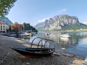 a boat sitting on the shore of a body of water at Silla House - A due passi dal lago in Malgrate