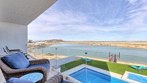 a balcony with chairs and a view of the water at Luxury Retreat Playa Laguna: 5-Bedroom Bliss in Puerto Peñasco