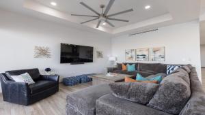 a living room with two couches and a ceiling fan at Luxury Retreat Playa Laguna: 5-Bedroom Bliss in Puerto Peñasco