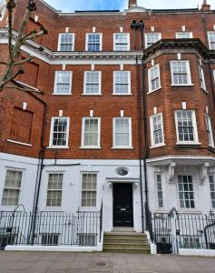 a large red brick building with a black door at Chelsea - Sloane Avenue by Viridian Apartments in London