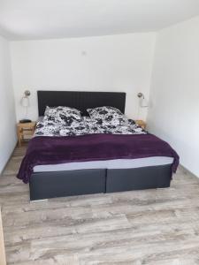 a bedroom with a bed with a purple comforter at Ferienhaus Toni im Stadtkern von Bremervörde in Bremervörde