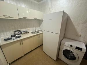 a kitchen with a white refrigerator and a washing machine at Ios Guest House 2 in K'obulet'i