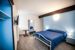 una camera con un letto blu e un tavolo di Casa di Bruno a Pellio Superiore