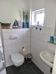 a white bathroom with a toilet and a sink at Ferienhaus Toni im Stadtkern von Bremervörde in Bremervörde +25 photos